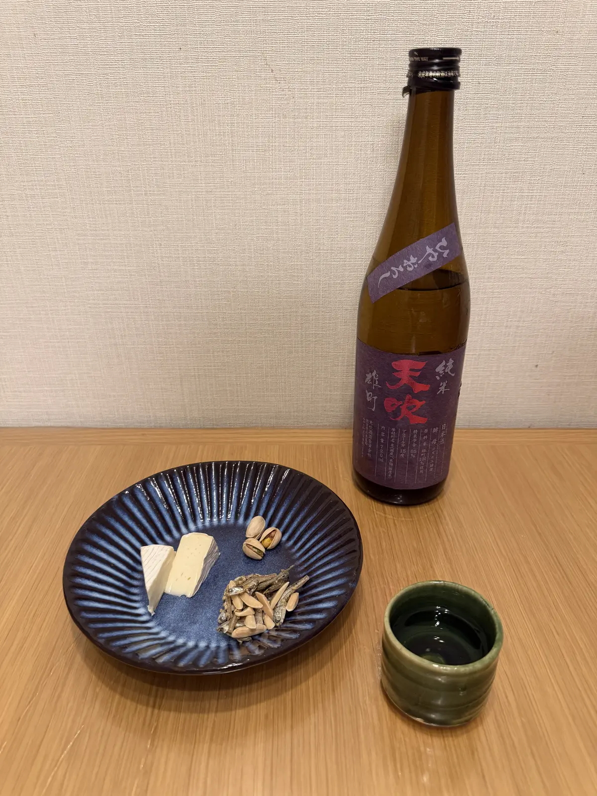 Amabuki hiyaoroshi with cheese, pistachios, and almond-and-small-fish snacks beside an Oribe guinomi