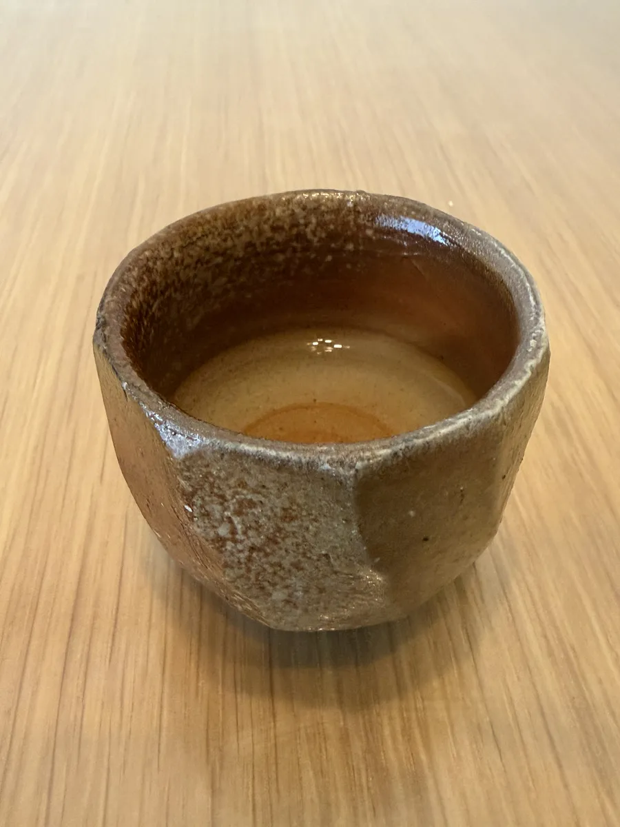 Angled view of the Bizen guinomi showing its faceted sides and rough unglazed surface