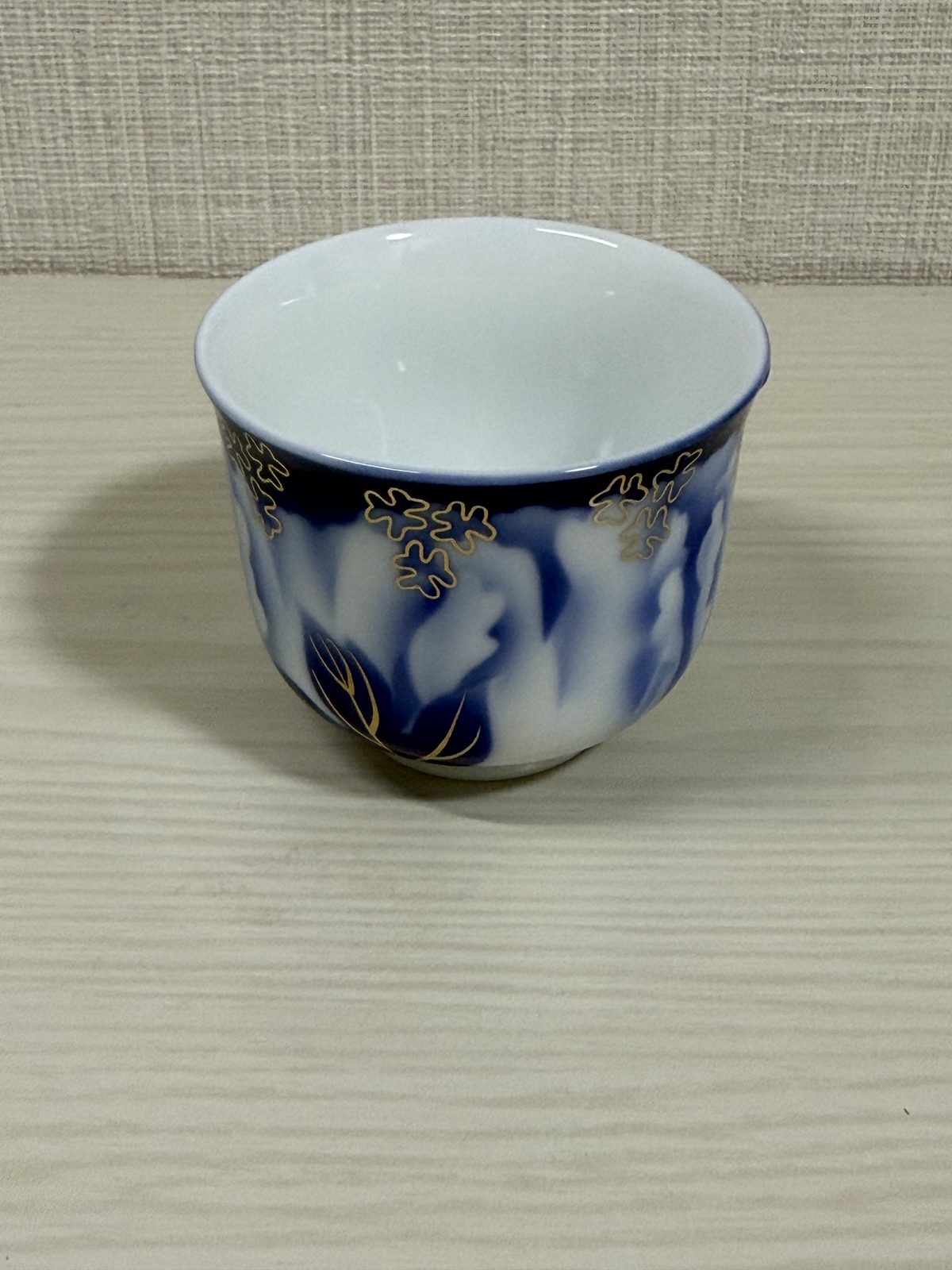 Close-up of the Fukagawa Seiji guinomi showing the cobalt, white, and gold detail