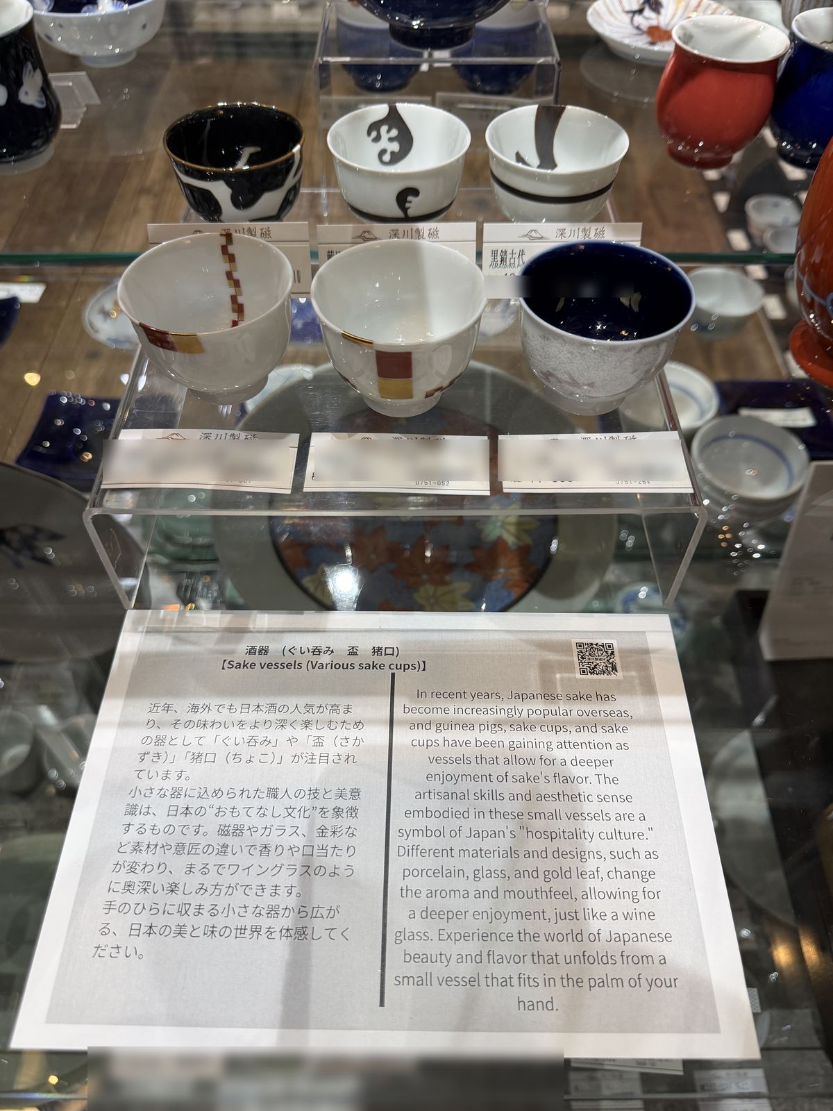 Sake vessels on display with an English explanation at Fukagawa Seiji Hakata