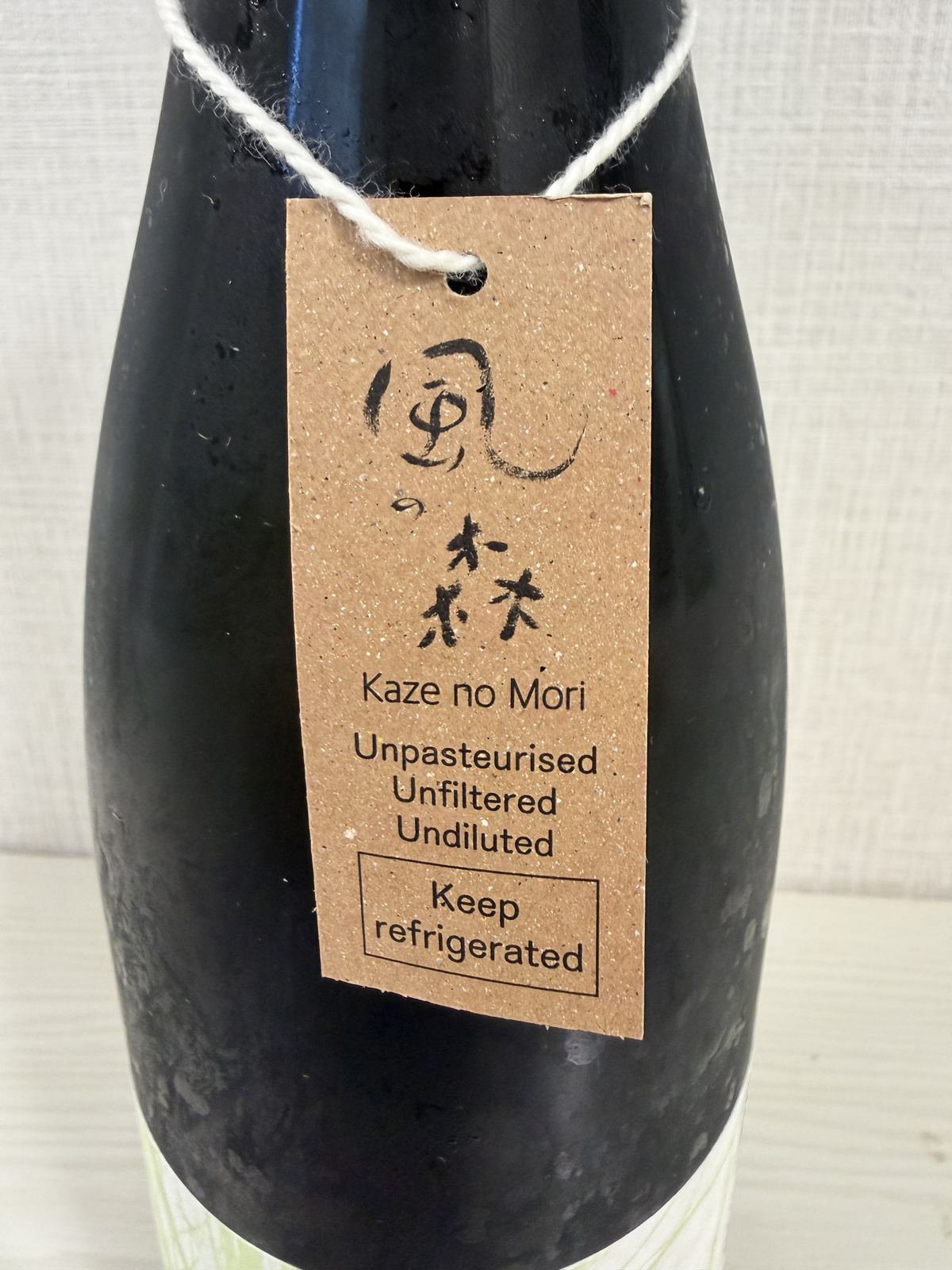 Kaze no Mori neck tag showing Unpasteurised, Unfiltered, Undiluted, and Keep refrigerated