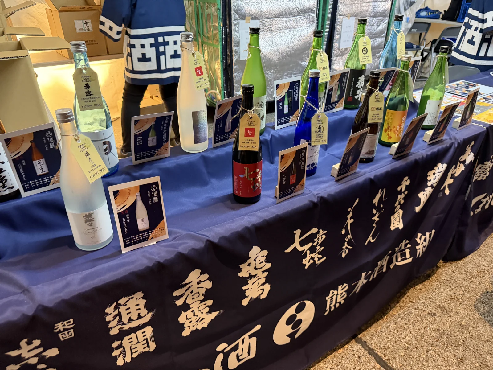 Sake bottles with price tags on the Kumamoto Sake Brewers Association sales table