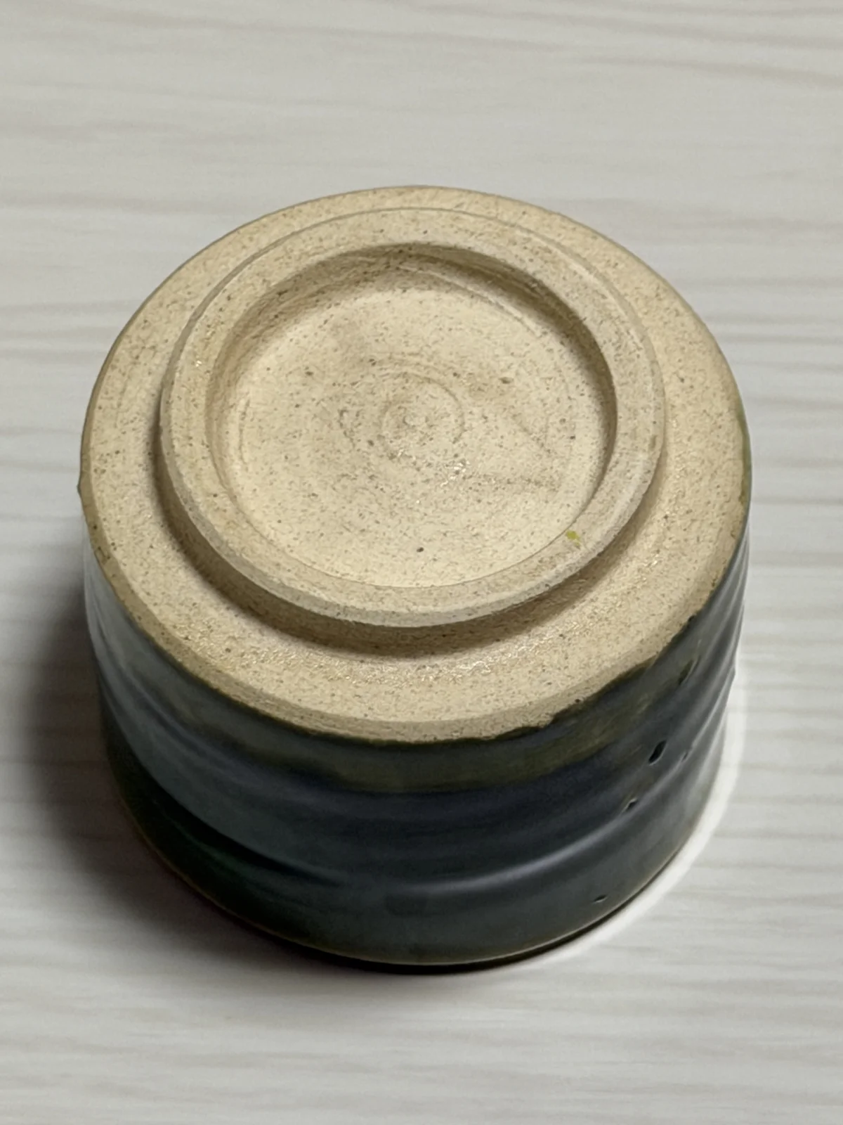 Underside of the Oribe ware guinomi, showing the pale unglazed foot ring