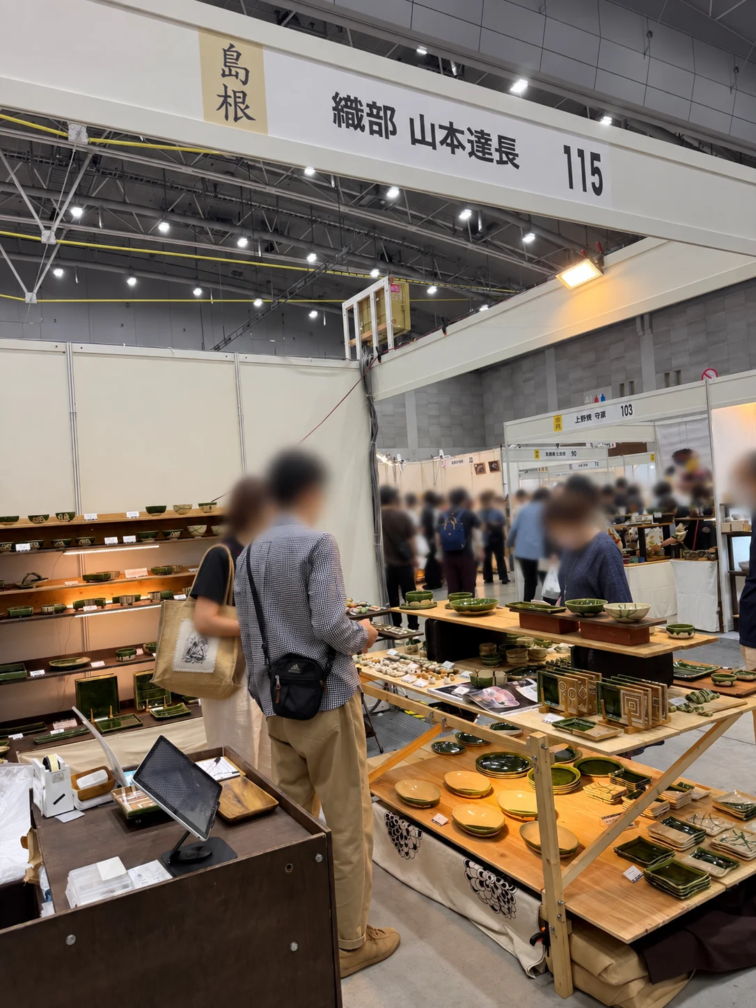 The Tatsunaga Yamamoto booth at the West Japan Ceramics Fair, with shelves and tables of green tableware