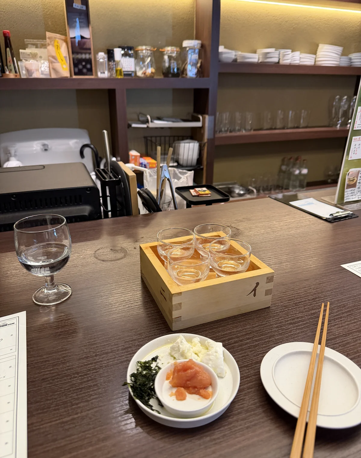 The counter at Sumiyoshi Shuhan with a tasting flight and mentaiko plate